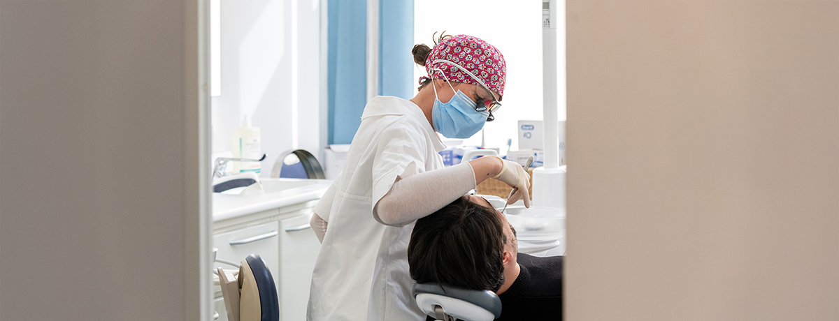 Una dentista dello Studio Pellitteri esamina un paziente su una poltrona da dentista