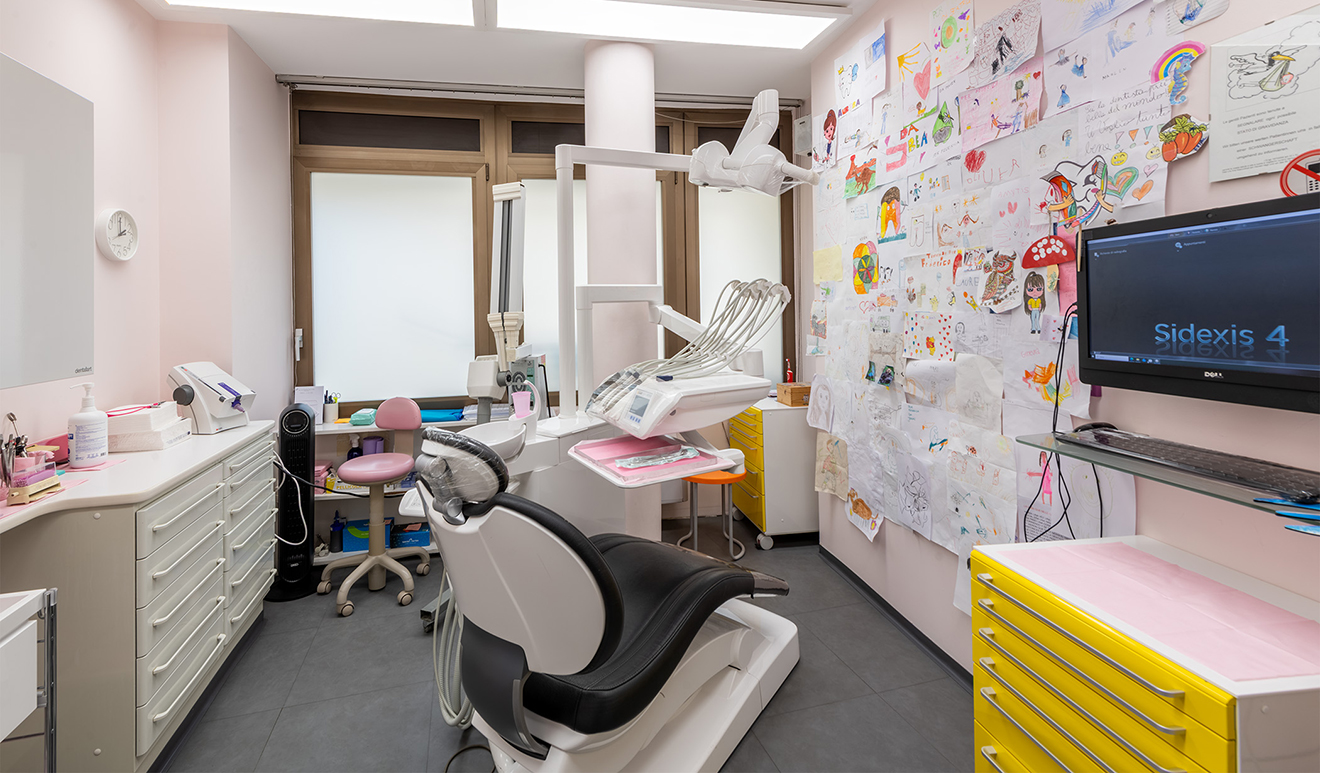 Studio dentistico moderno e accogliente con poltrona odontoiatrica, strumenti e disegni di bambini alle pareti
